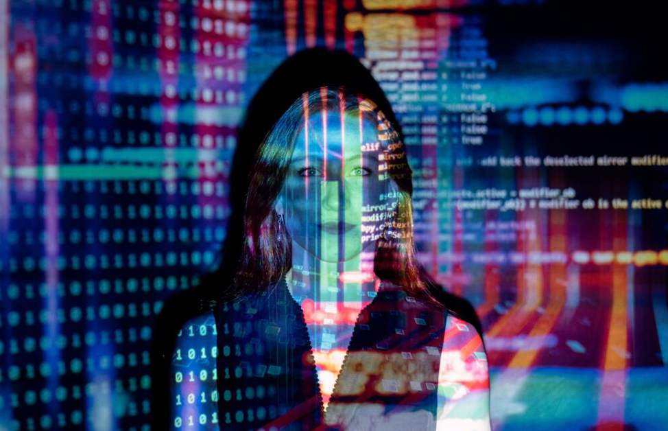 Woman standing in front of wall with lines of computer code projected over her